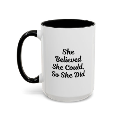 White ceramic motivational coffee mug with black script reading "She Believed She Could, So She Did" on a plain background.