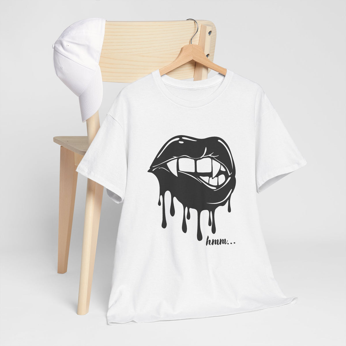 Graphic T-shirt by Printify featuring dripping lips and a "hmm..." bite design on a casual black tee.