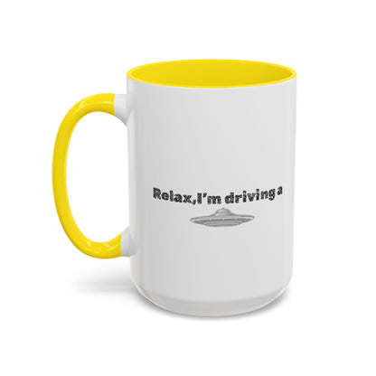 Ceramic coffee mug with "Relax, I’m Driving" UFO design, 11 oz size, featuring a colorful alien and spaceship illustration.