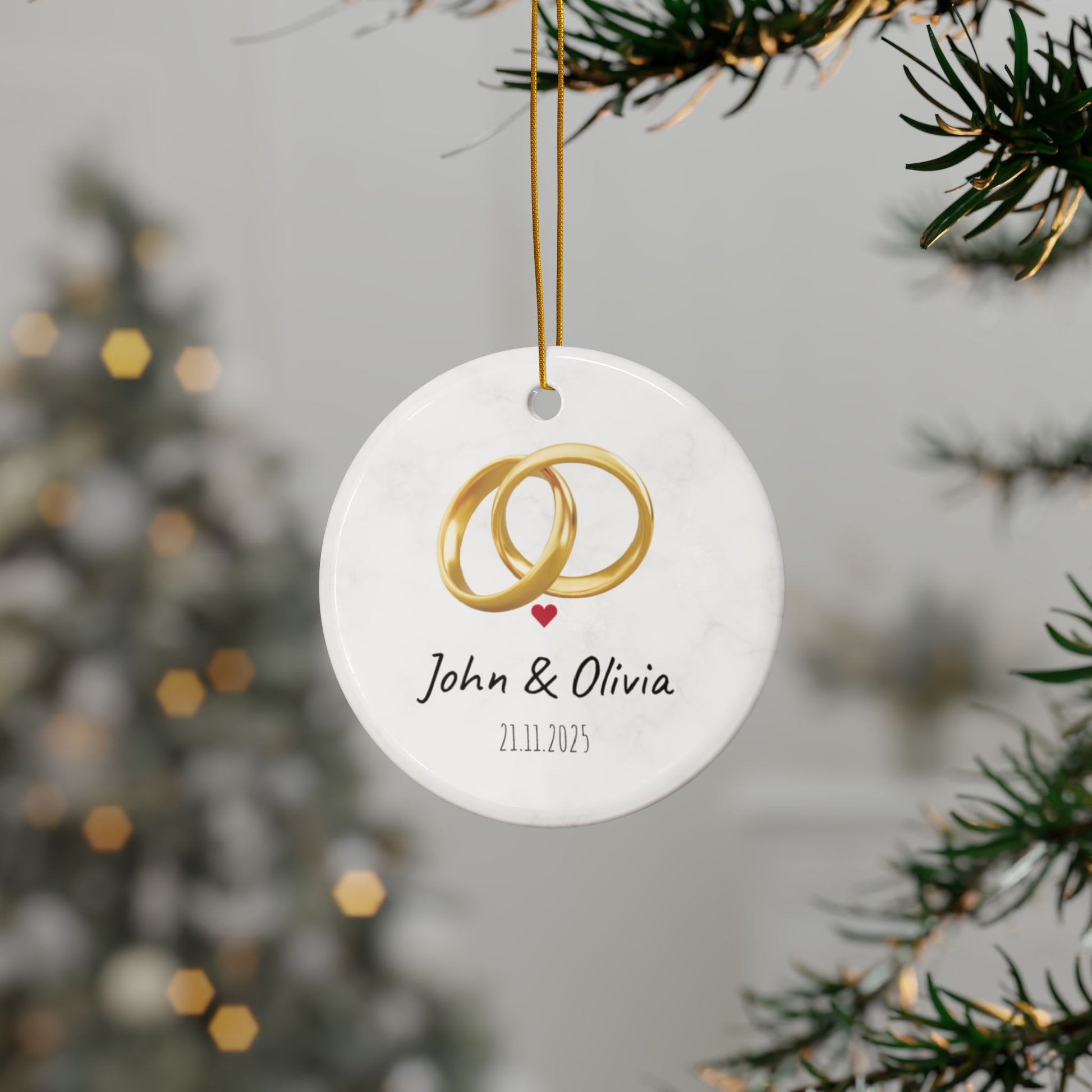 Round ceramic wedding ring ornament with personalized names and date, featuring elegant design and smooth finish.