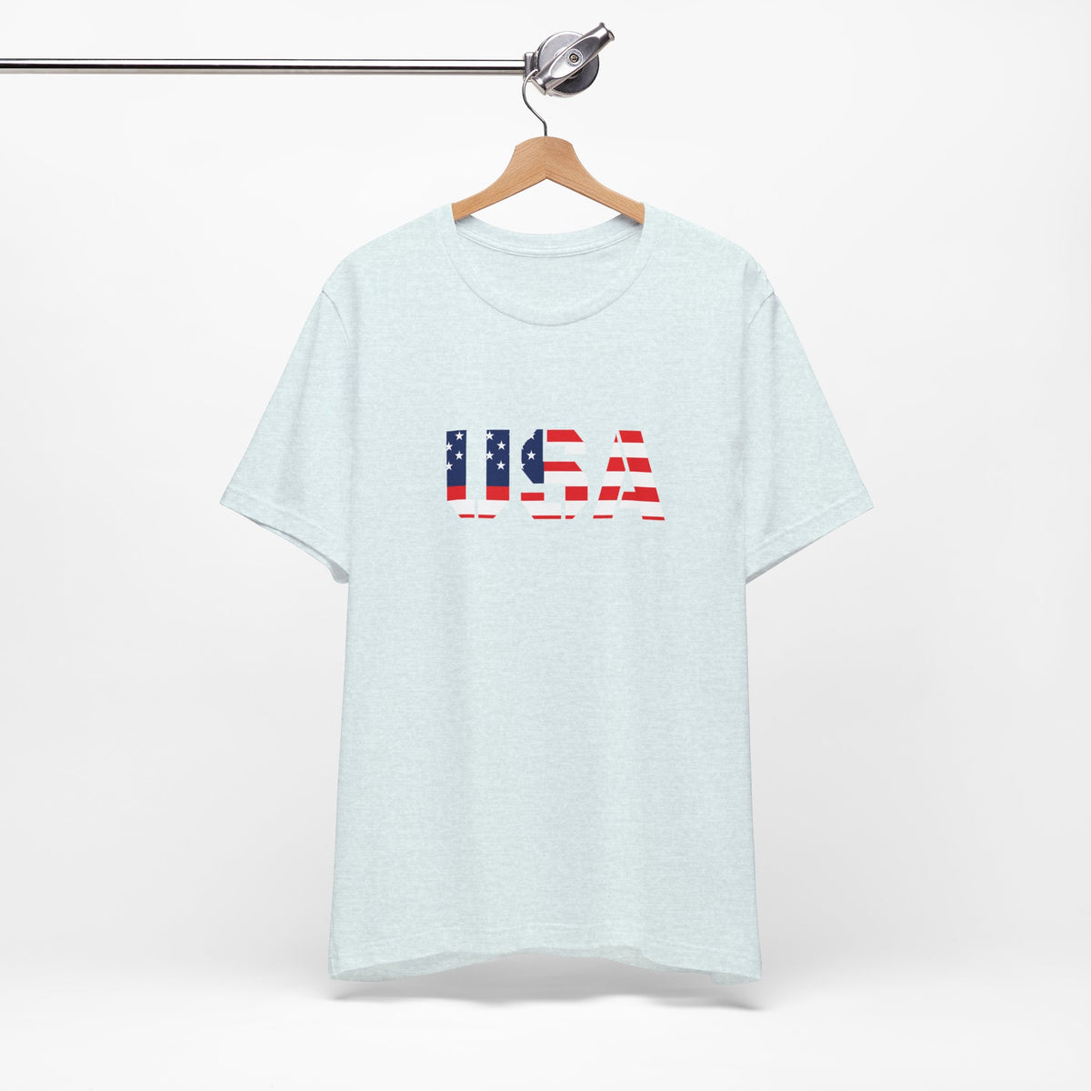 USA flag text T-shirt by Printify featuring patriotic Fourth of July design, casual cotton T-shirt with bold red, white, and blue flag graphic.