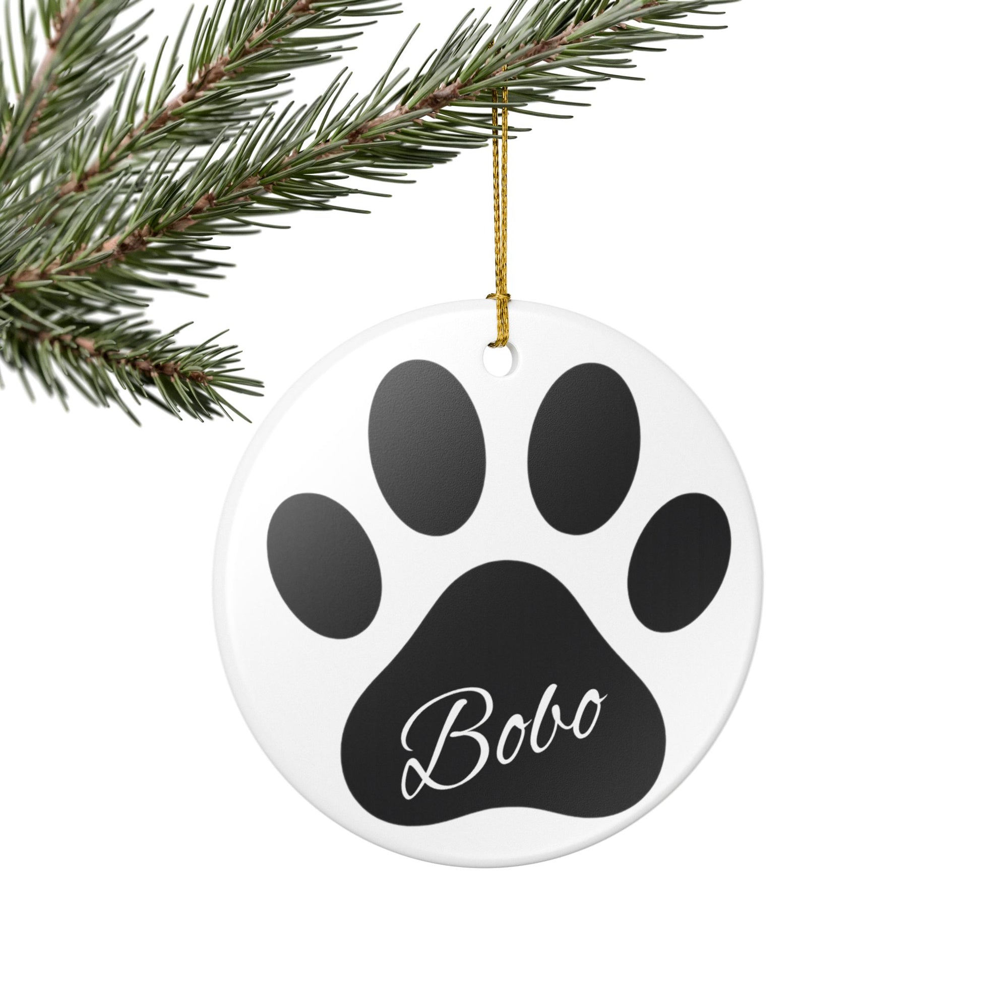 Black paw print ceramic ornament with pet's name, perfect for memorial Christmas decoration, by Printify.