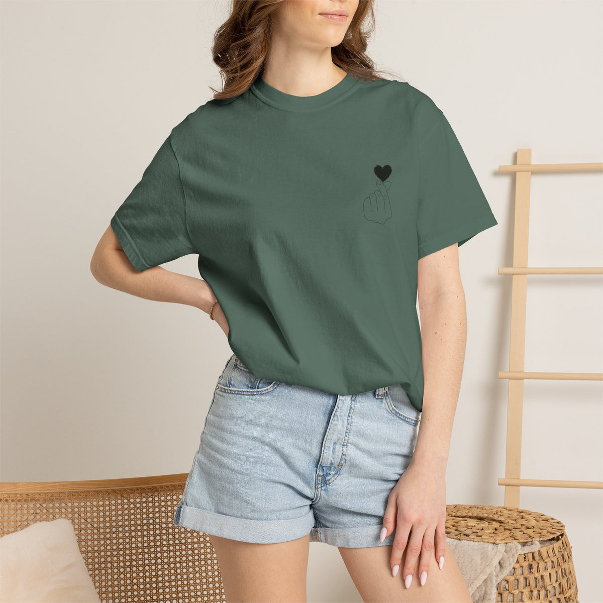 Minimal black heart graphic T-shirt by Printify featuring a finger heart design on a casual black tee.