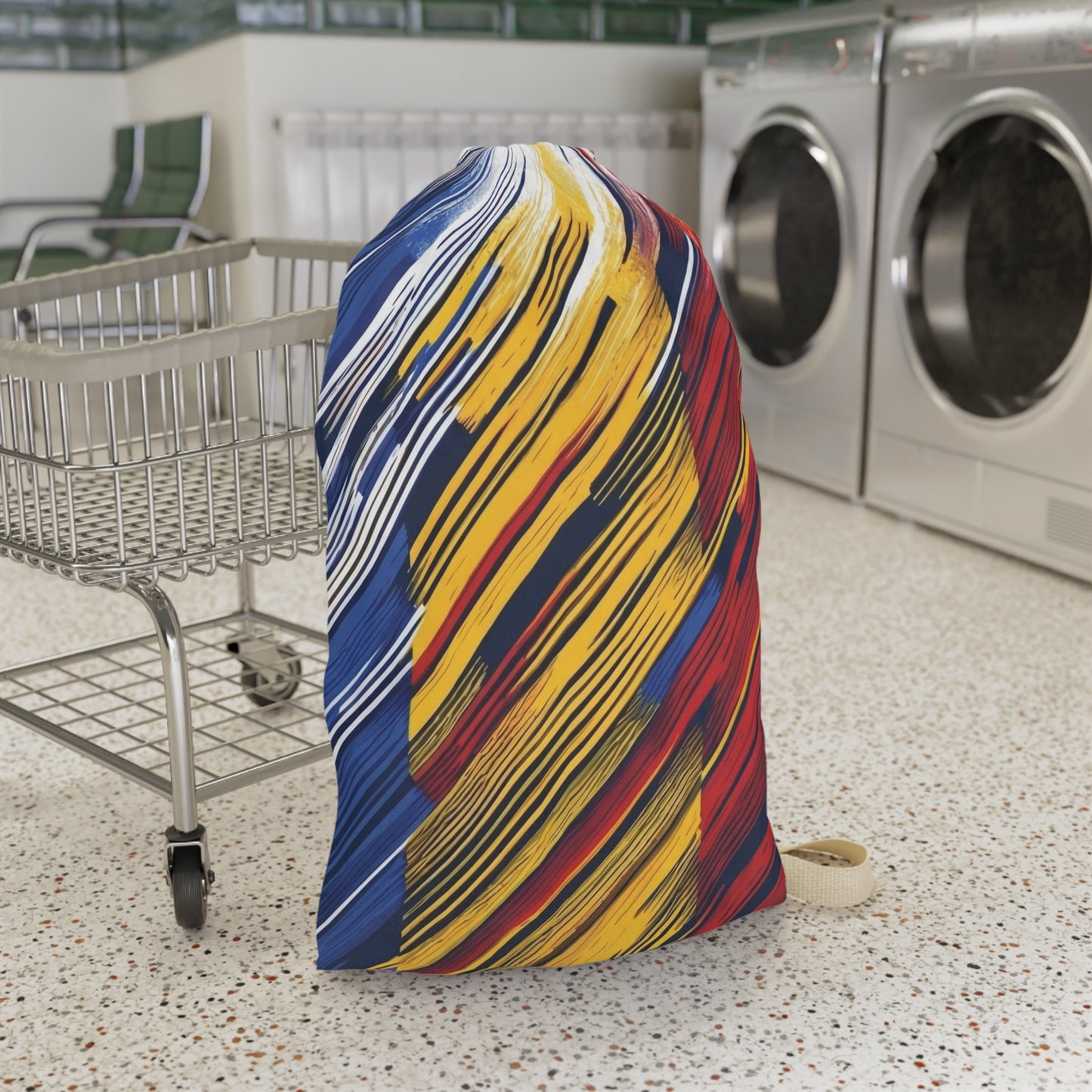 Colorful abstract brushstroke laundry bag in red, yellow, and blue, made by Printify, ideal for dorms and travel storage.