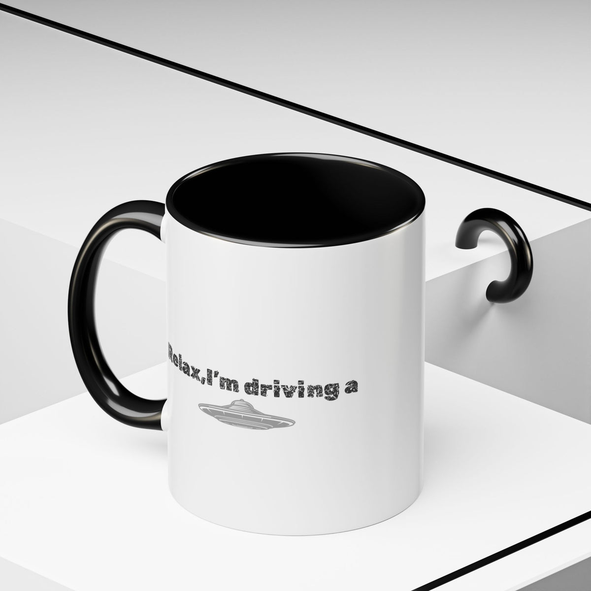 Ceramic coffee mug with "Relax, I’m Driving" UFO design in 11 oz or 15 oz size, featuring a colorful alien and spaceship illustration.