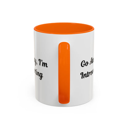 Ceramic mug with "Go Away, I'm Introverting" text, 11 oz size, featuring a white exterior and black handle for coffee or tea.