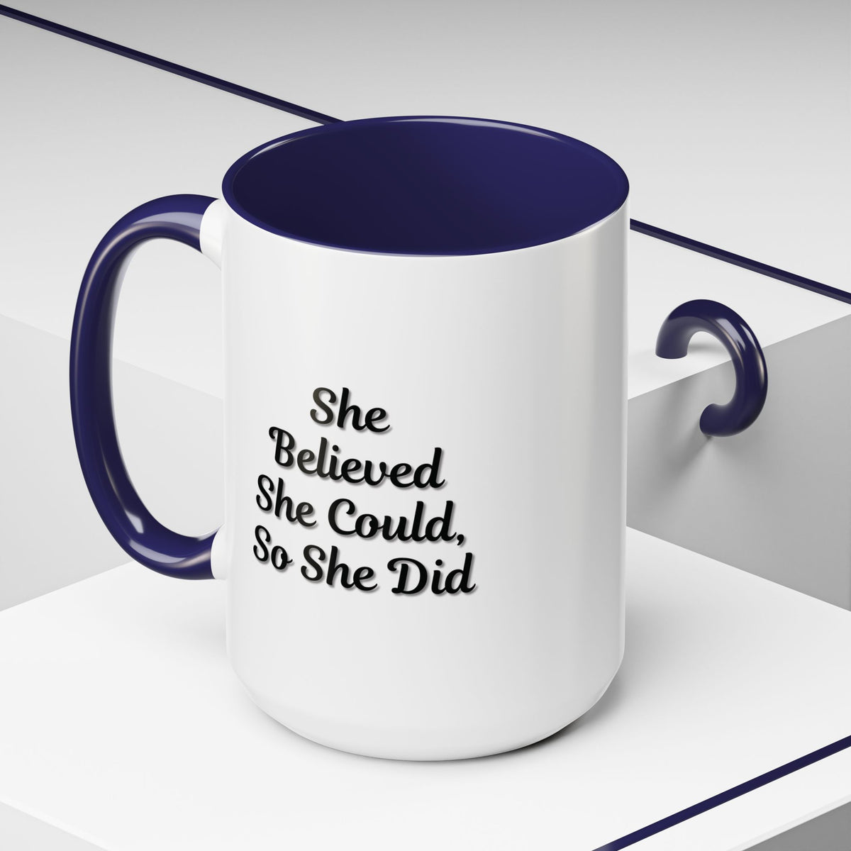Motivational coffee mug with "She Believed She Could, So She Did" quote in black text on a white ceramic mug.