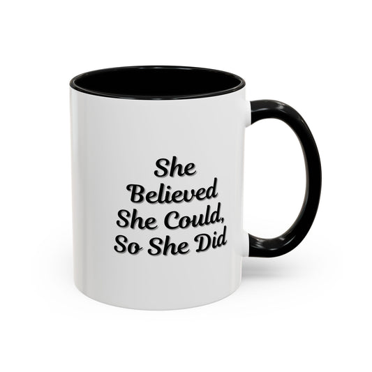 Motivational coffee mug with "She Believed She Could, So She Did" quote in black text on white ceramic mug.