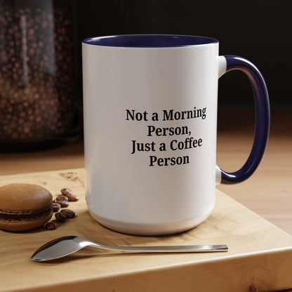 Ceramic coffee mug with "Not a Morning Person, Just a Coffee Person" text, featuring a white background and colorful lettering.