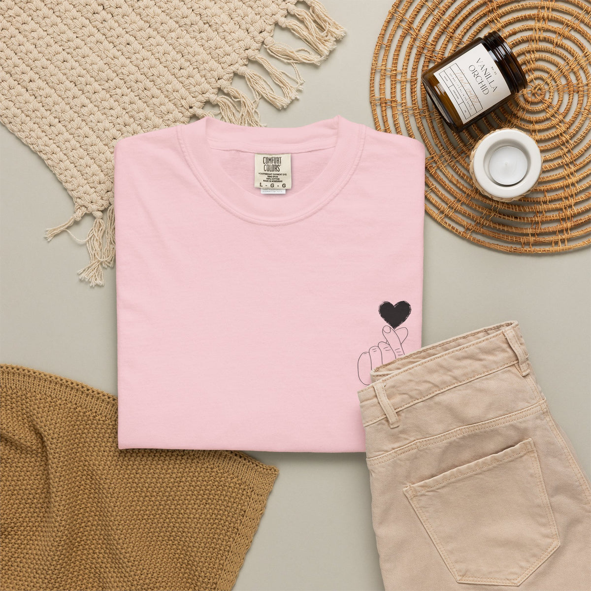 Black T-shirt with a minimal white finger heart graphic, casual style, by Printify, displayed on a flat surface.