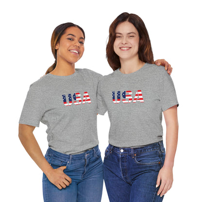 USA flag text T-shirt by Printify, featuring patriotic July Fourth design with bold red, white, and blue colors on a casual tee.
