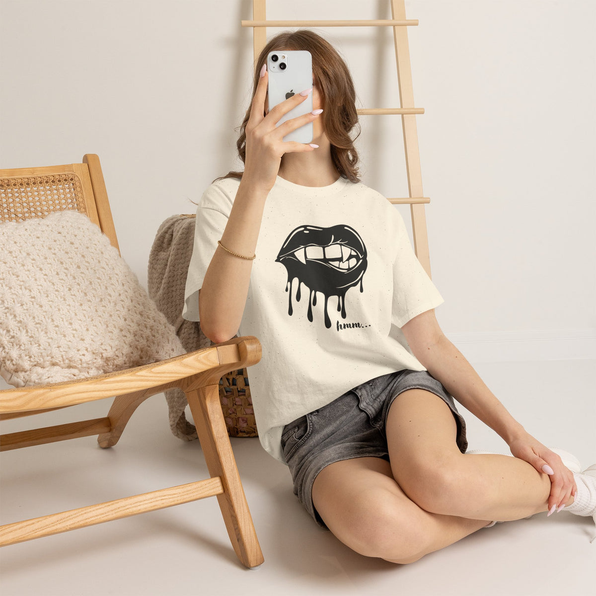 Black graphic t-shirt with dripping lips and "hmm..." bite design, featuring bold print by Printify.