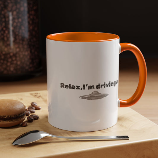 Ceramic coffee mug with "Relax, I’m Driving" UFO accent design in 11 oz size, featuring a playful space-themed print.