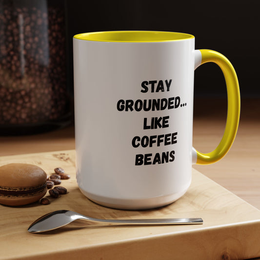 Black ceramic mug featuring "Stay Grounded Like Coffee Beans" quote, perfect for coffee lovers, 11oz size.