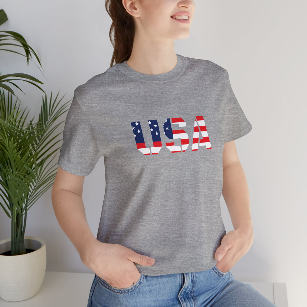 USA flag text T-shirt by Printify featuring patriotic design, perfect for Fourth of July celebrations, displayed on a hanger.