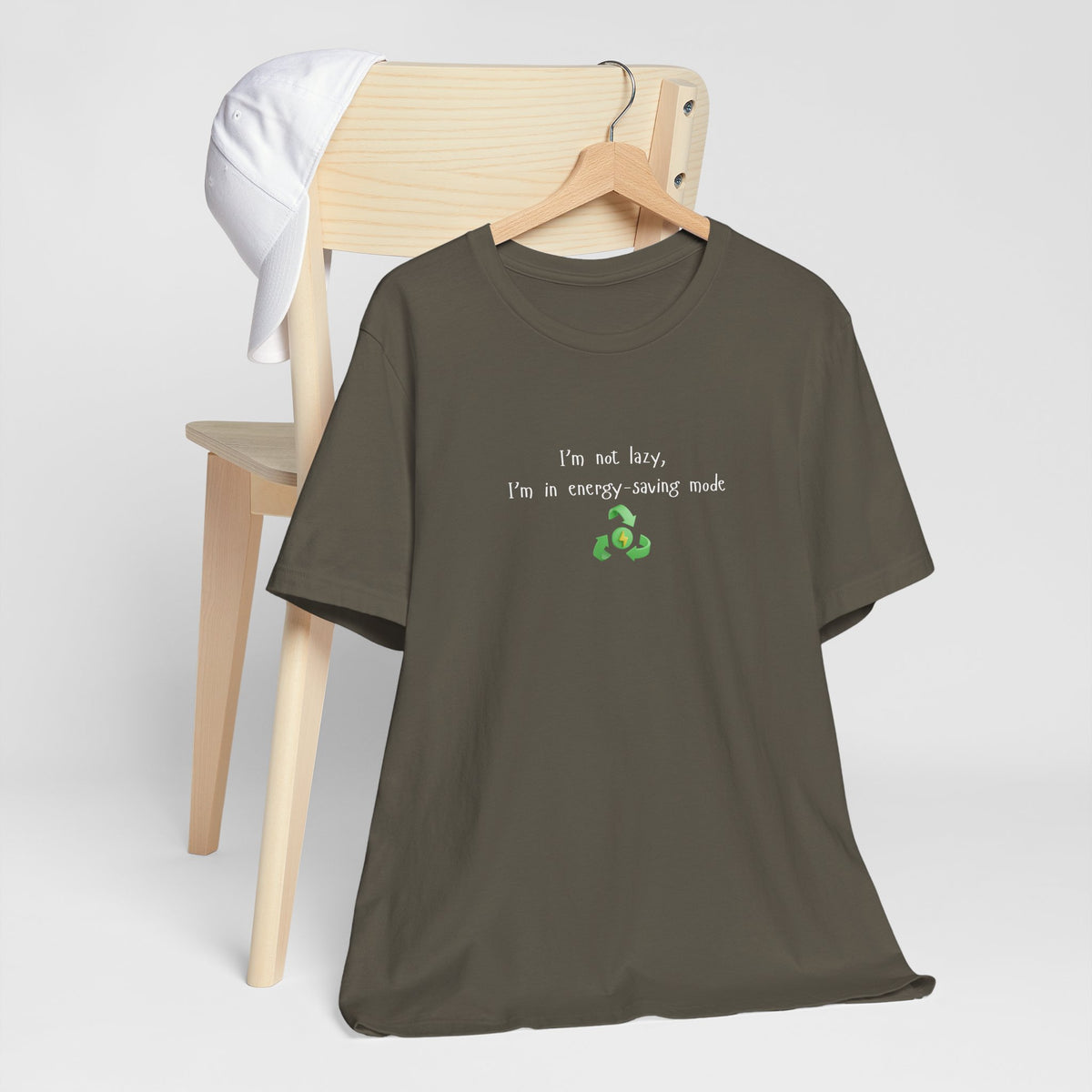 Eco-friendly mock T-shirt with humorous print saying "I’m Not Lazy, I’m an Energy-Saving Mock" by Printify.