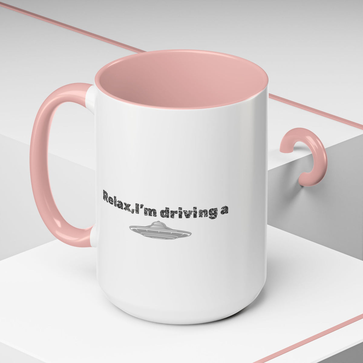 Ceramic coffee mug with UFO accent and "Relax, I’m Driving" text, available in 11 or 15 oz sizes, by Printify.
