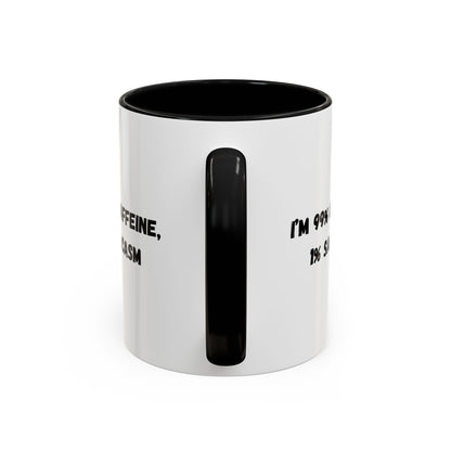 Ceramic coffee mug with "I'm 99% Caffeine, 1% Sarcasm" printed design, featuring a white background and curved handle.