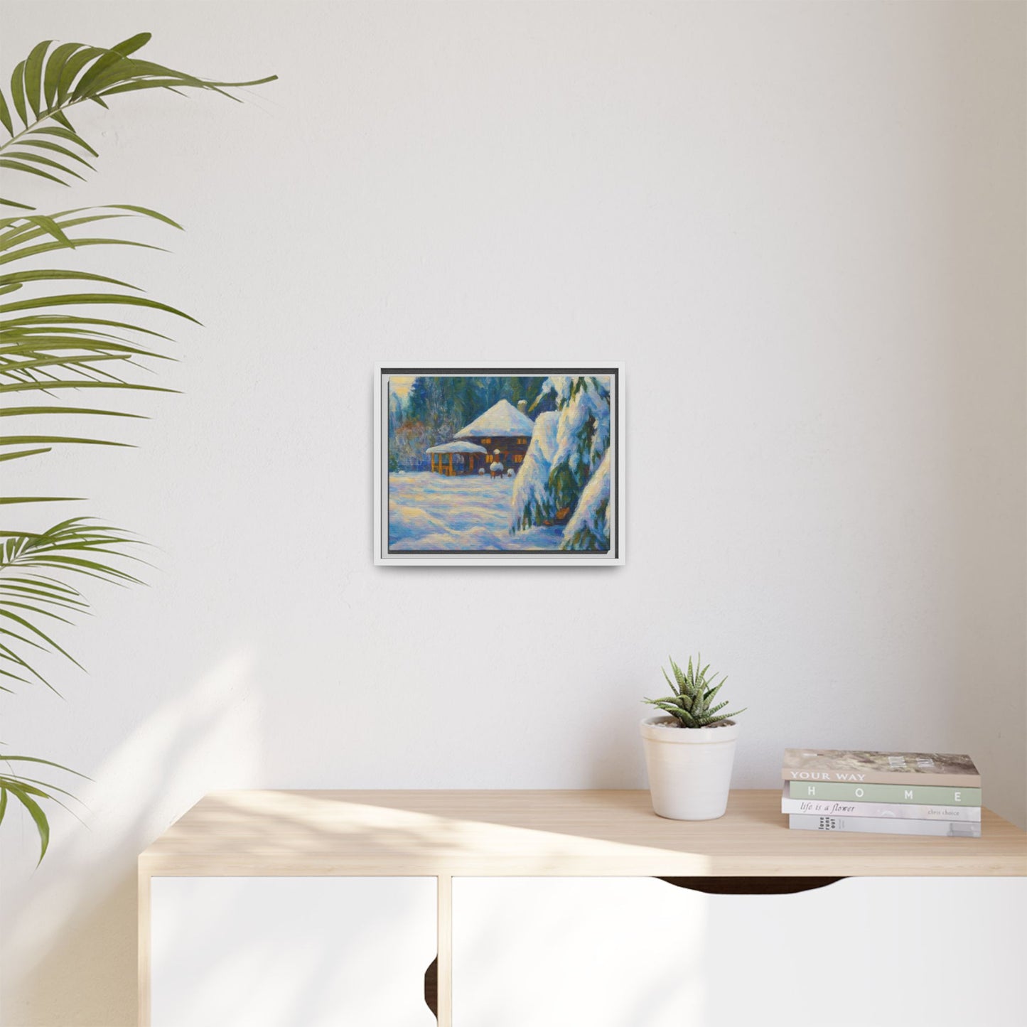 Framed matte canvas wall art of a snowy cabin winter landscape, featuring a cozy snow-covered scene with trees and mountains.