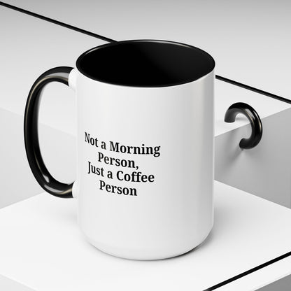 Ceramic coffee mug with "Not a Morning Person, Just a Coffee Person" text, featuring a white background and colorful lettering.