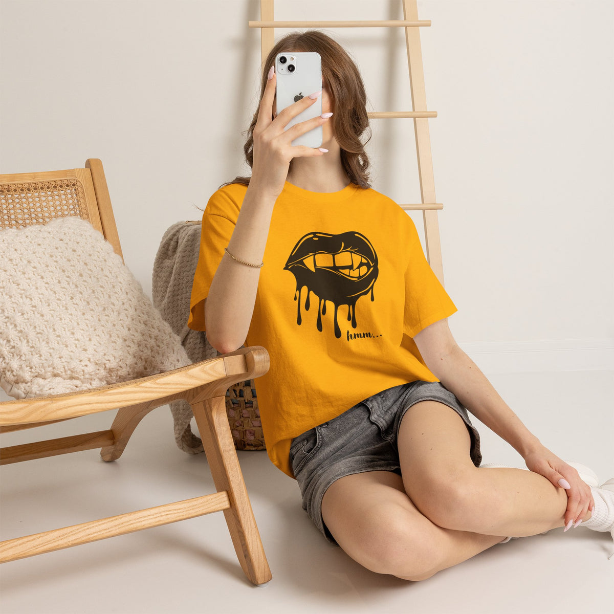 Black graphic T-shirt by Printify featuring dripping lips with "hmm..." bite design on the front.
