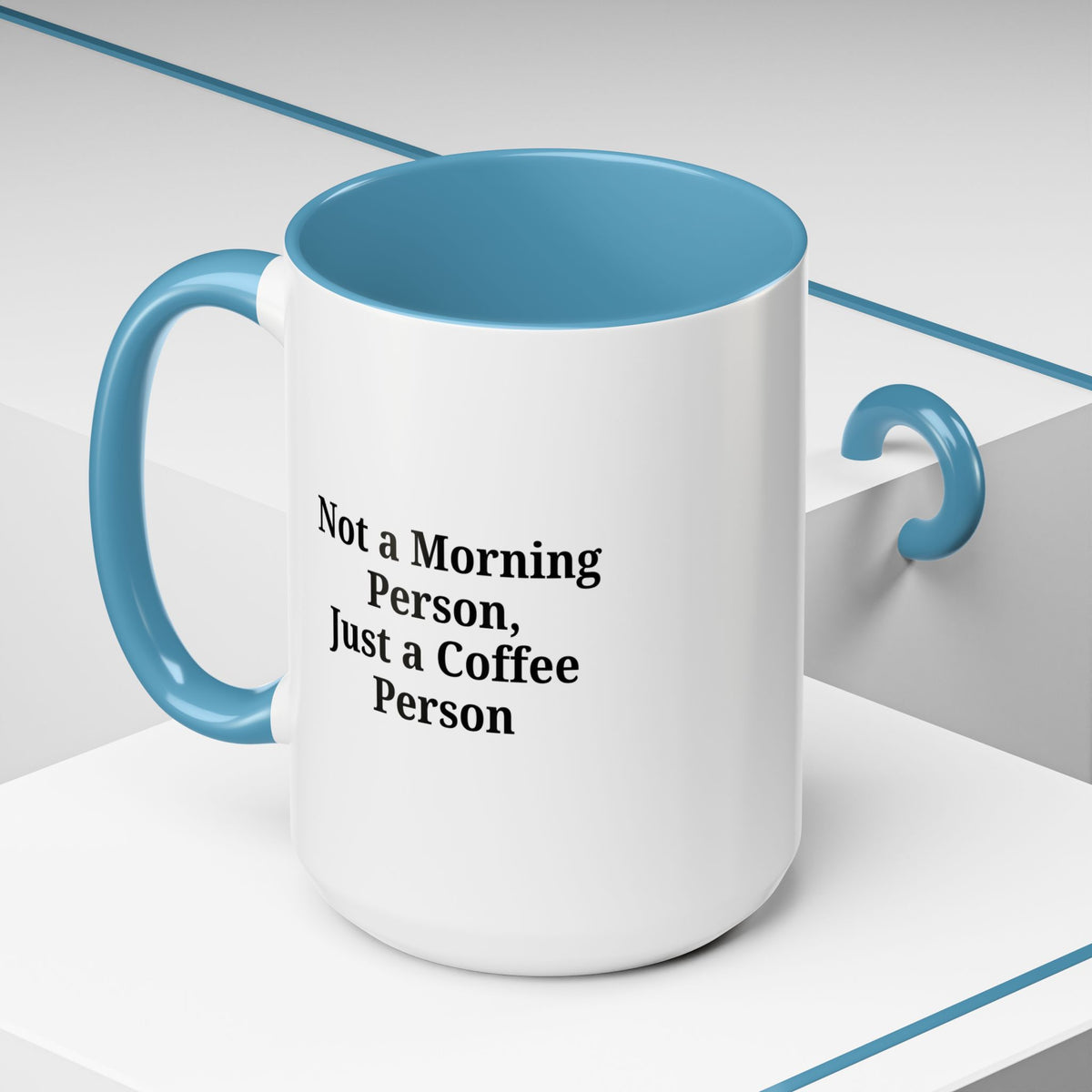Ceramic coffee mug with "Not a Morning Person, Just a Coffee Person" slogan, featuring a white background and colorful lettering.