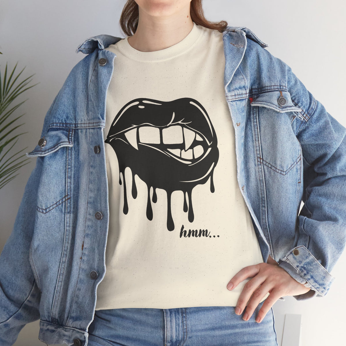 Black graphic T-shirt featuring dripping lips and "hmm..." bite design, by Printify, worn by a model