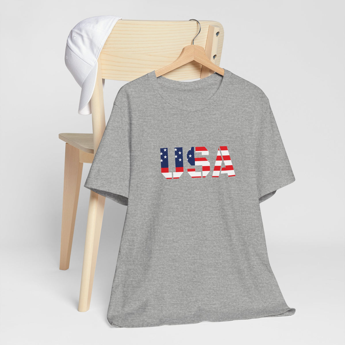 USA flag text t-shirt by Printify featuring patriotic red, white, and blue design for Fourth of July celebrations.