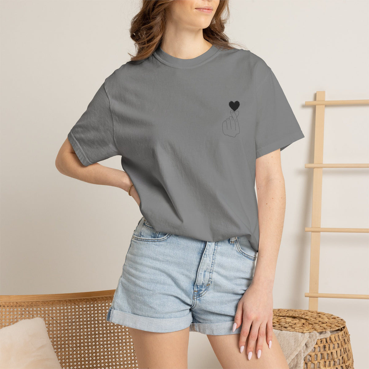 Black T-shirt with minimal heart graphic, featuring a finger heart design, by Printify.