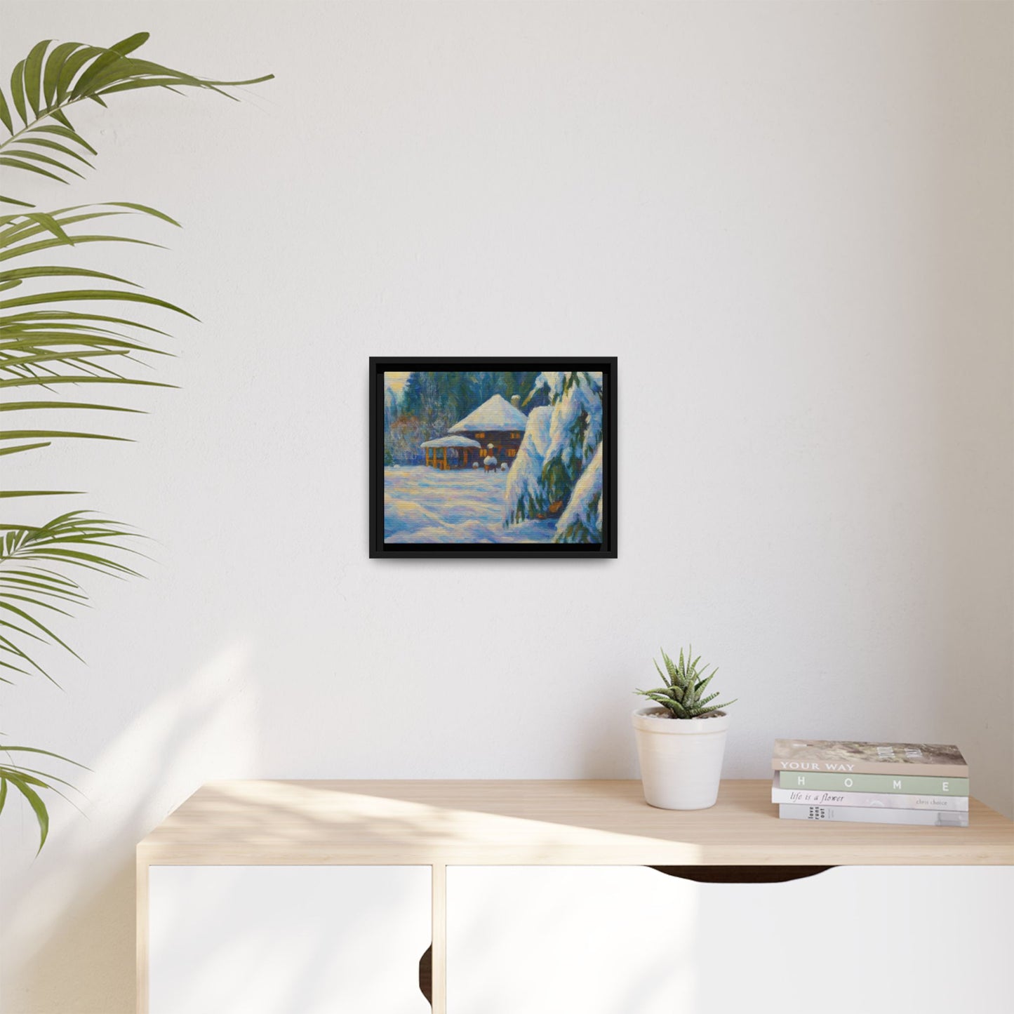 Framed matte canvas wall art featuring a snowy cabin winter landscape with trees and mountains, by Printify.