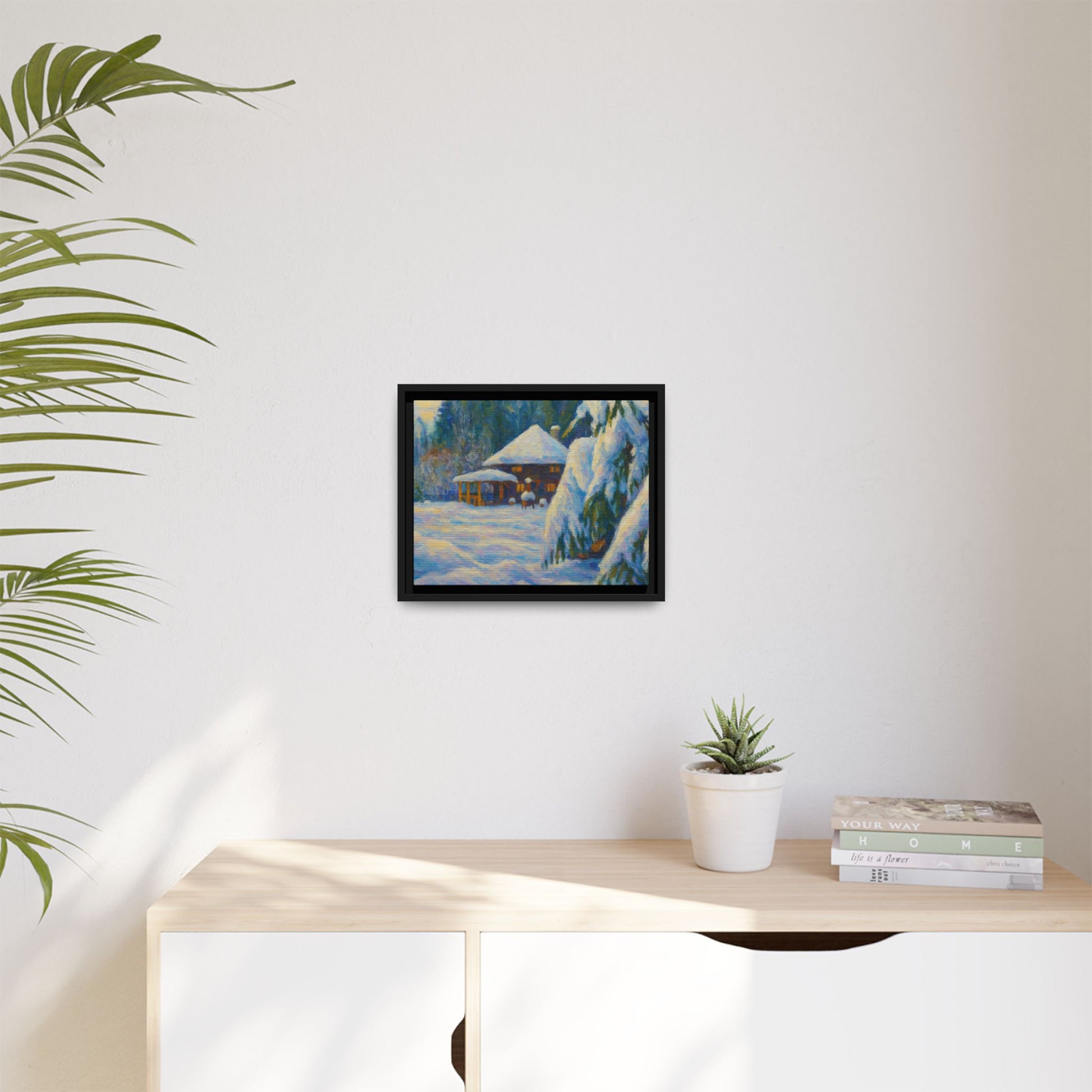 Framed matte canvas wall art featuring a snowy cabin winter landscape with trees and mountains, by Printify.