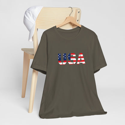 USA flag text T-shirt by Printify featuring patriotic Fourth of July design, casual cotton tee with bold red, white, and blue colors.