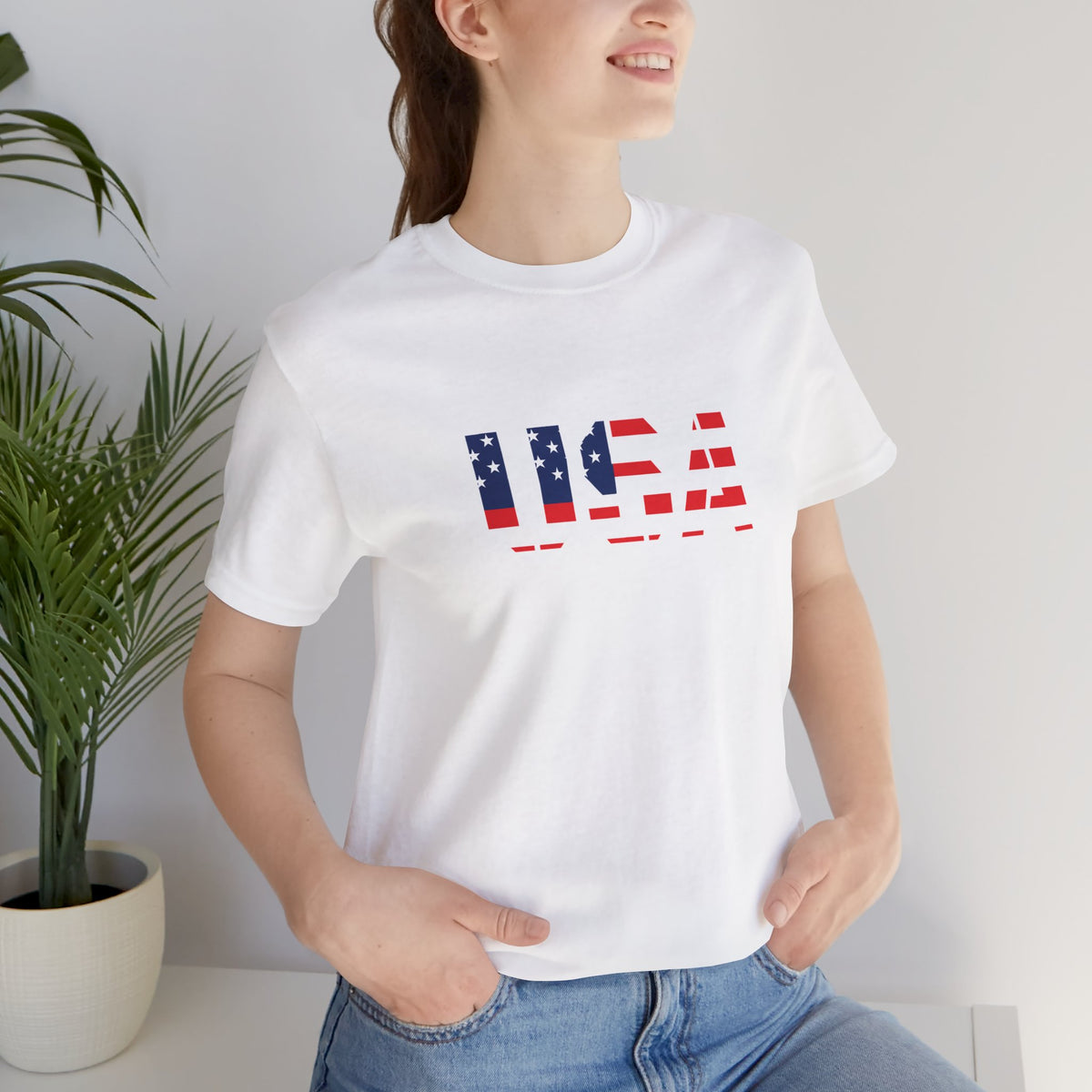 Red, white, and blue USA flag text T-shirt by Printify, featuring patriotic Fourth of July design on casual cotton tee.