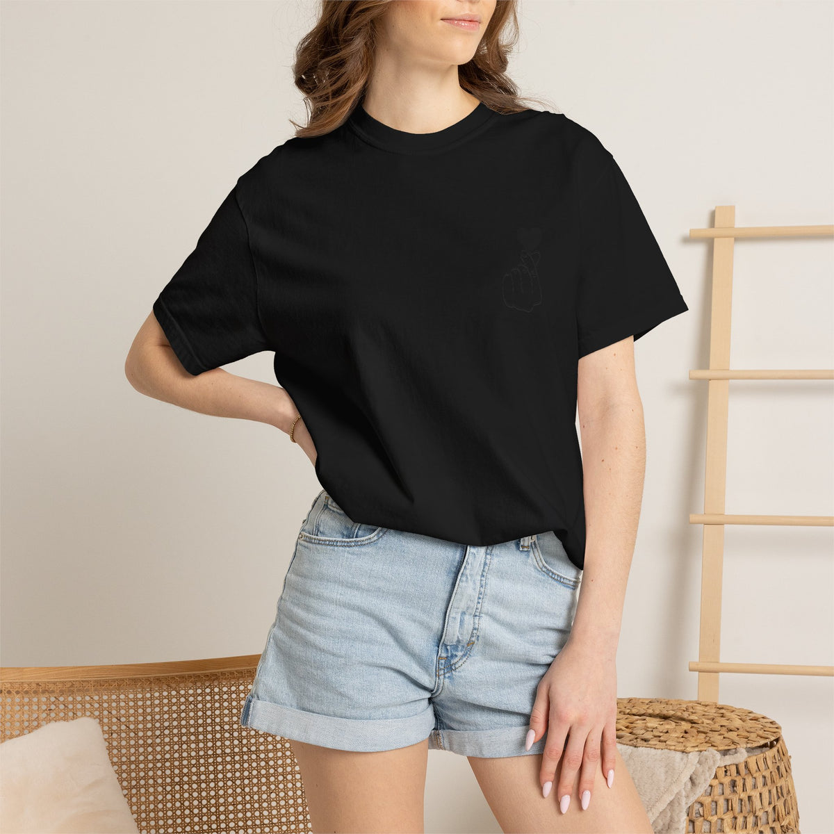 Black T-shirt with a minimal white finger heart graphic, featuring a simple heart design on the front.