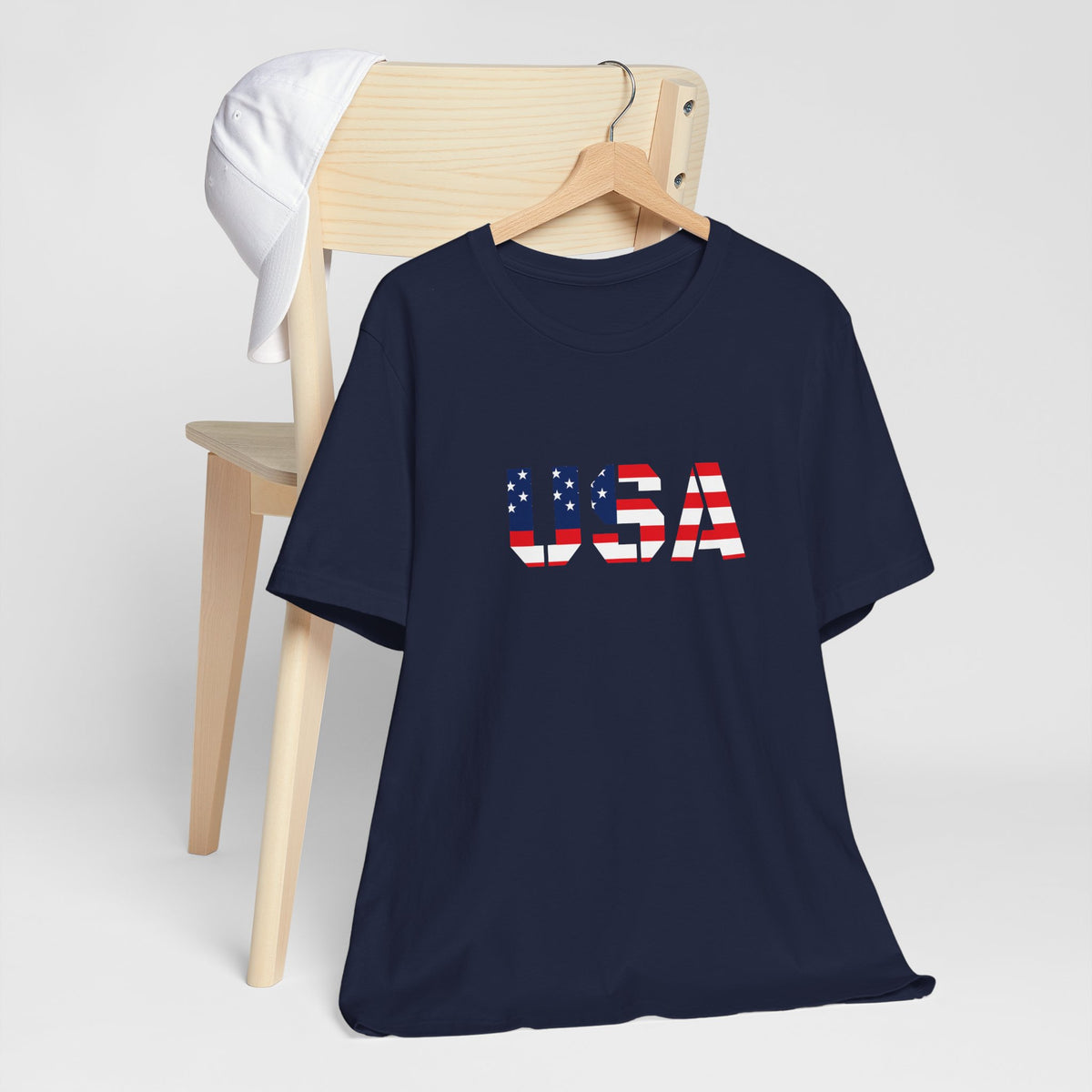 USA flag text T-shirt by Printify featuring patriotic Fourth of July design, with bold flag graphic and "USA" text on the front.