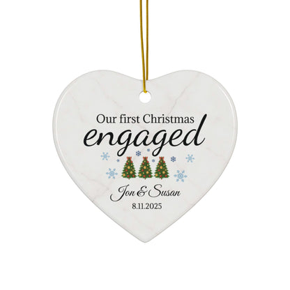 Ceramic "Our First Christmas Engaged" heart ornament with festive holiday design, perfect for celebrating a couple's engagement.