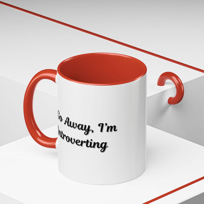 Ceramic coffee mug with "Go Away, I'm Introverting" slogan in black text, 11 oz size, on a white background.