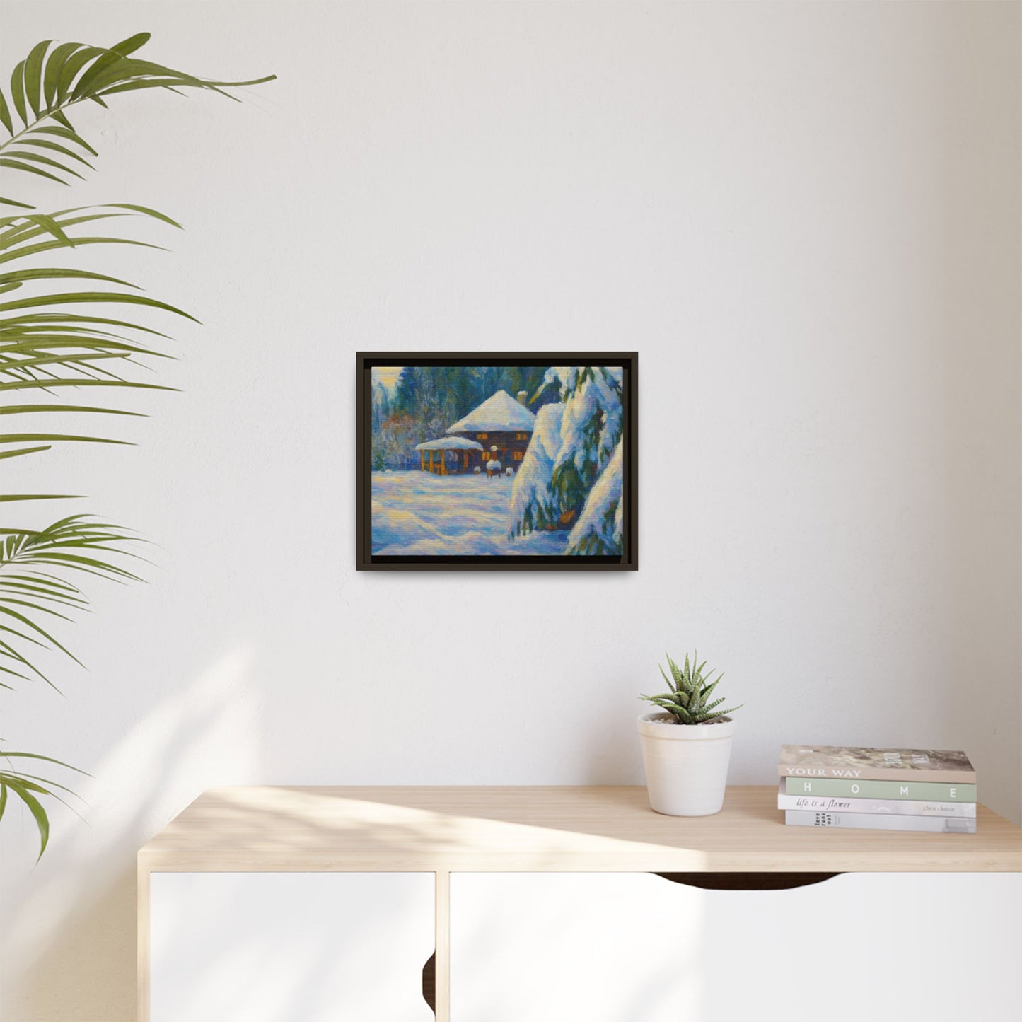 Framed matte canvas wall art of a snowy cabin winter landscape, featuring a cozy cabin surrounded by snow-covered trees.
