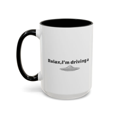 Ceramic coffee mug with "Relax, I’m Driving" UFO accent design, available in 11 oz or 15 oz sizes, by Printify.
