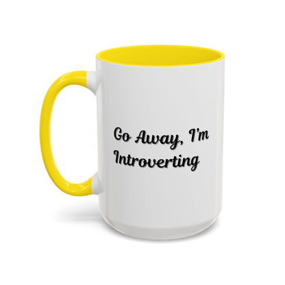Ceramic coffee mug with "Go Away, I'm Introverting" quote, 11 oz, black handle and white body, designed for introverts.