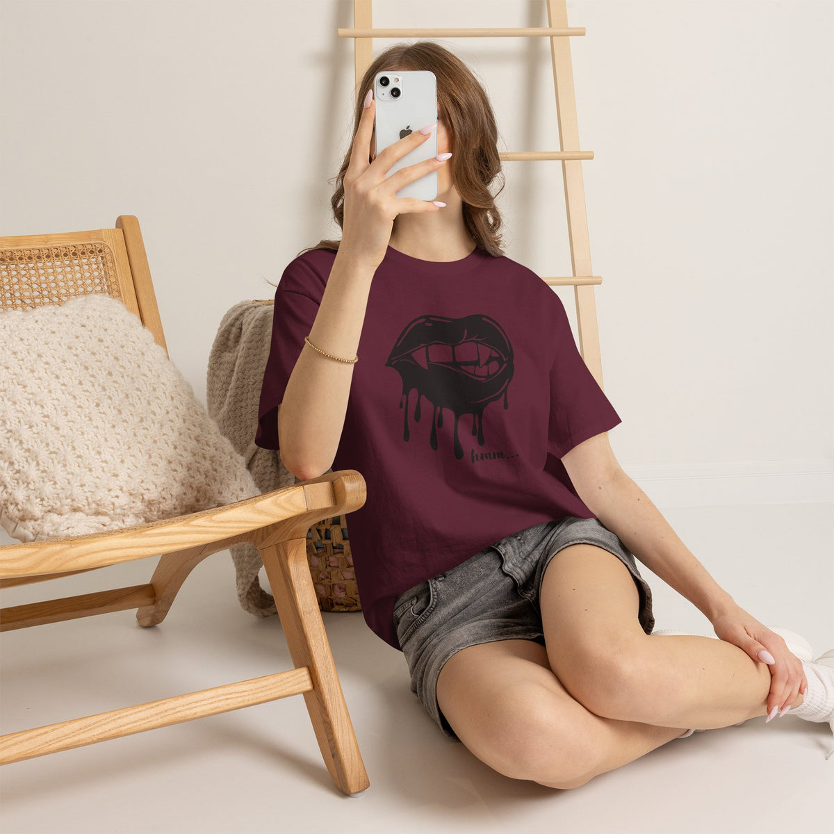 Graphic T-shirt featuring dripping lips and a "hmm..." bite design, showcasing bold, artistic print on a Printify T-shirt.