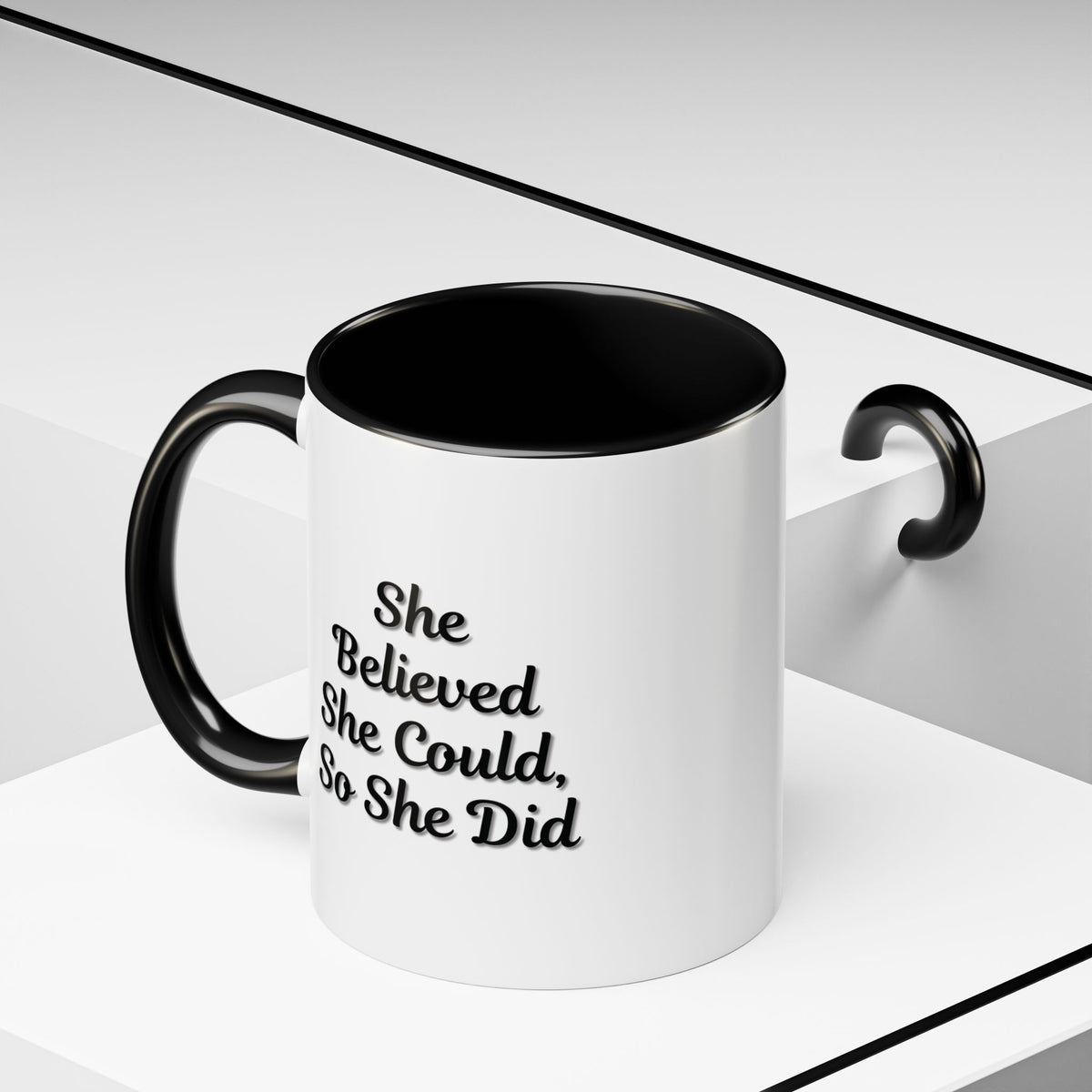Motivational coffee mug with the quote "She Believed She Could, So She Did" in black text on a white ceramic mug.