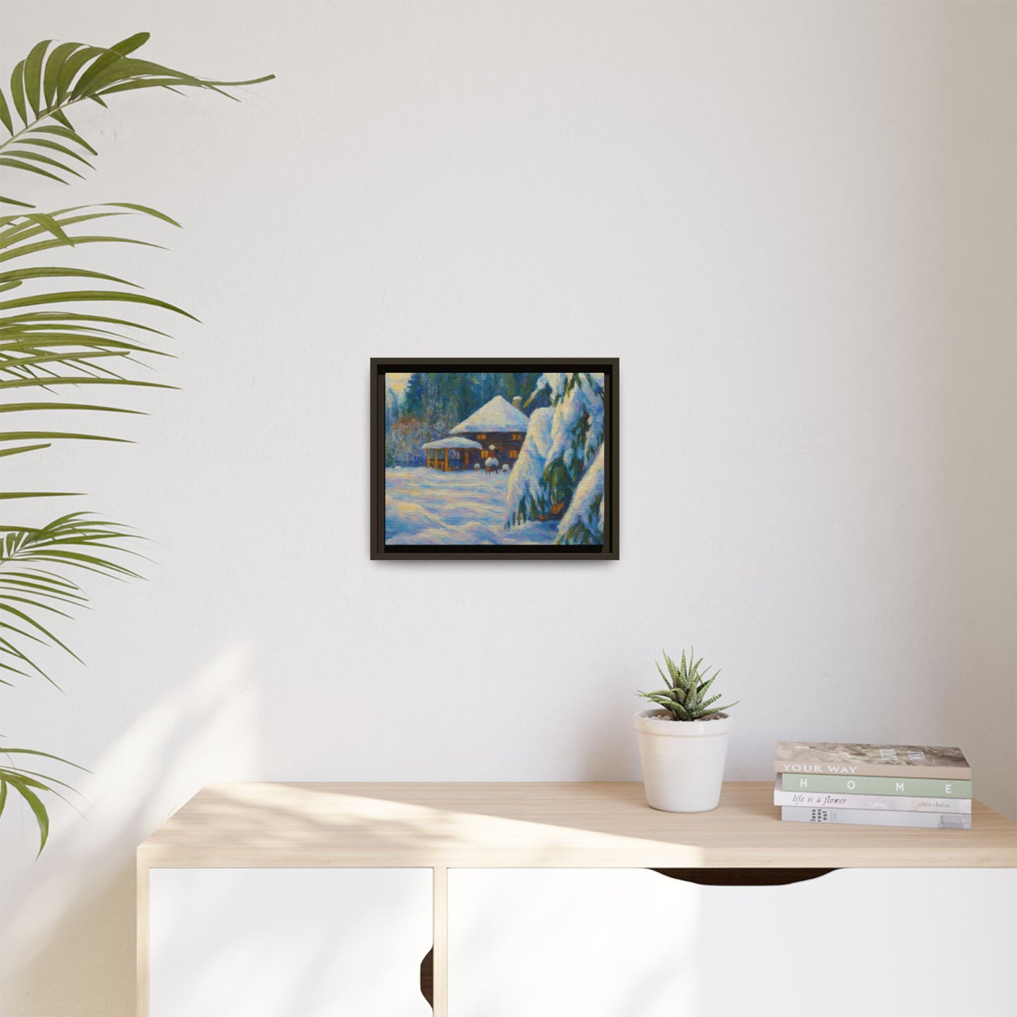 Framed matte canvas print of a snowy cabin winter landscape wall art by Printify, showcasing a cozy winter scene with snow-covered trees.