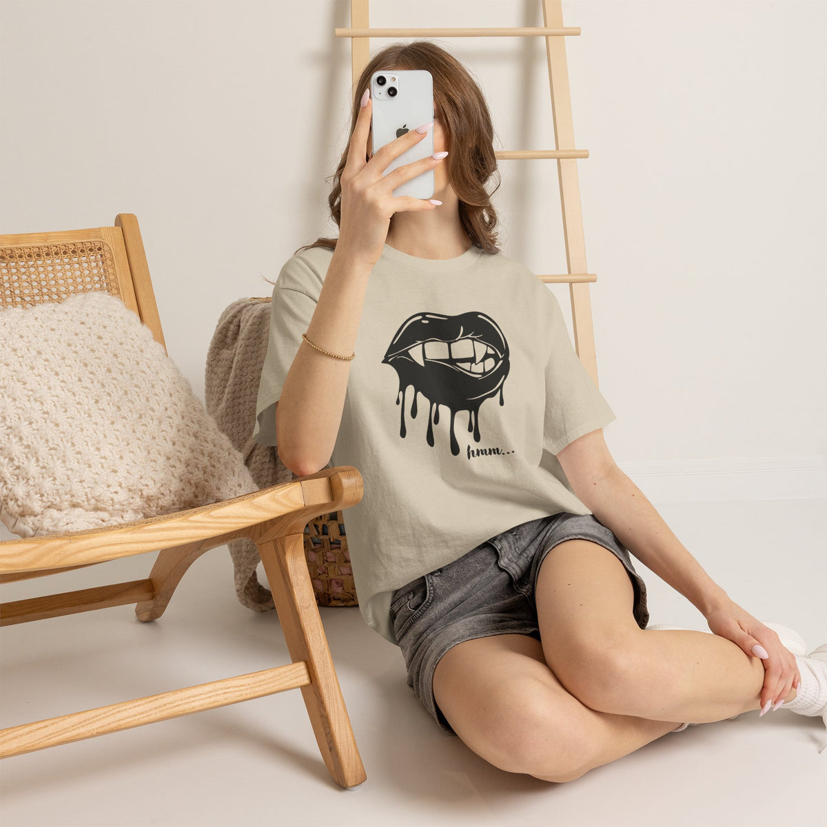 Black graphic t-shirt featuring dripping lips with "hmm..." bite design, by Printify, showing the bold, artistic print on the front.