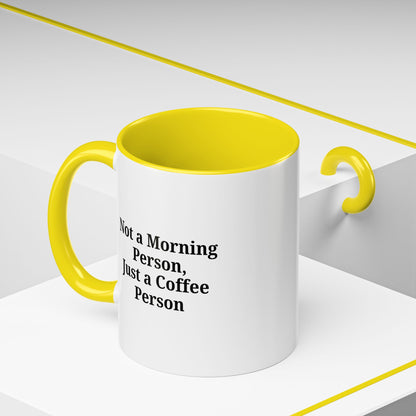 White ceramic coffee mug with black text reading "Not a Morning Person, Just a Coffee Person" on a plain background.