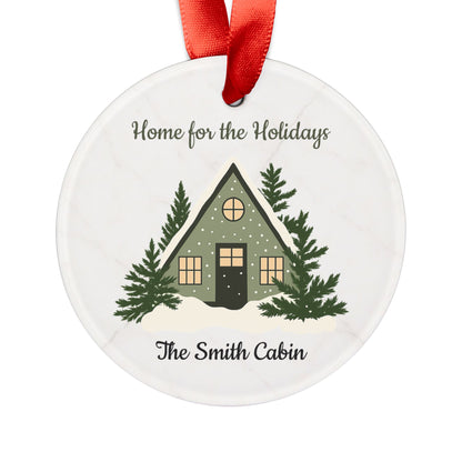 Acrylic "Home for the Holidays" cabin ornament with festive winter scene, ideal for holiday decorations and Christmas tree embellishments.