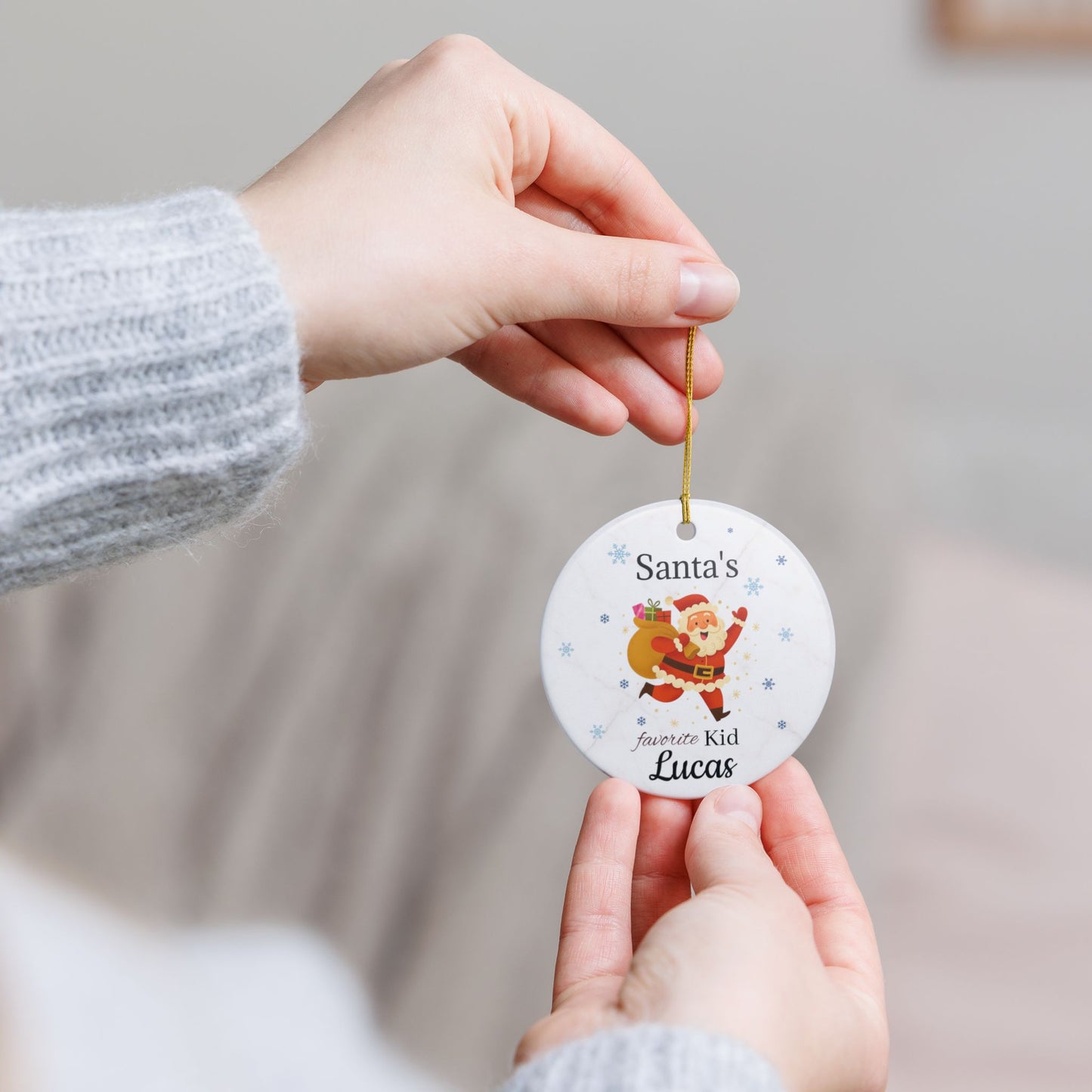 Personalized Santa's Favorite Kid ceramic ornament featuring the name Lucas, with festive holiday design and red ribbon.