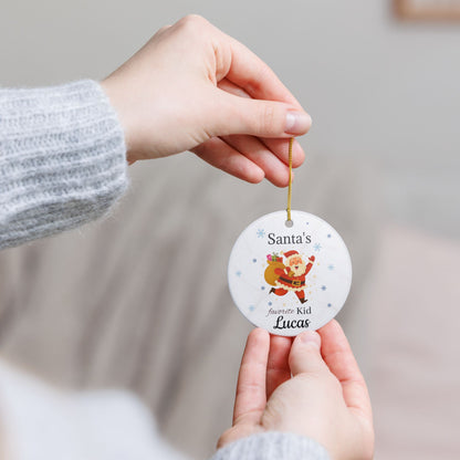 Personalized Santa's Favorite Kid ceramic ornament featuring the name Lucas, with festive holiday design and red ribbon.
