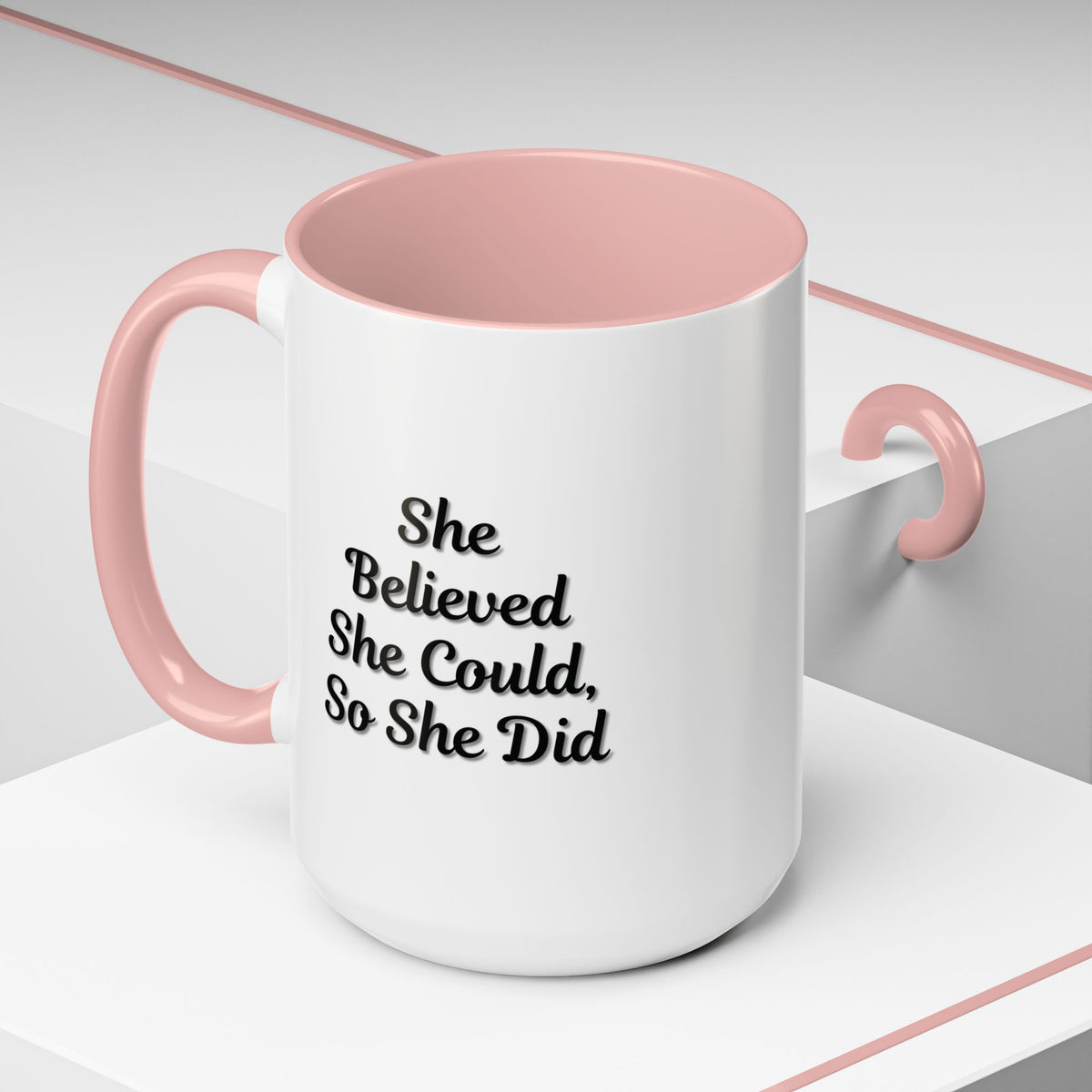 White ceramic motivational coffee mug with black text reading "She Believed She Could, So She Did" from Printify.