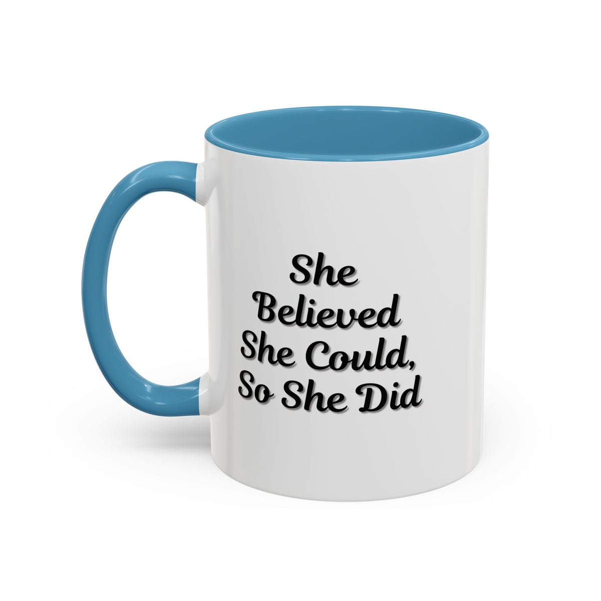 White ceramic motivational coffee mug with black text reading "She Believed She Could, So She Did" on a plain background.